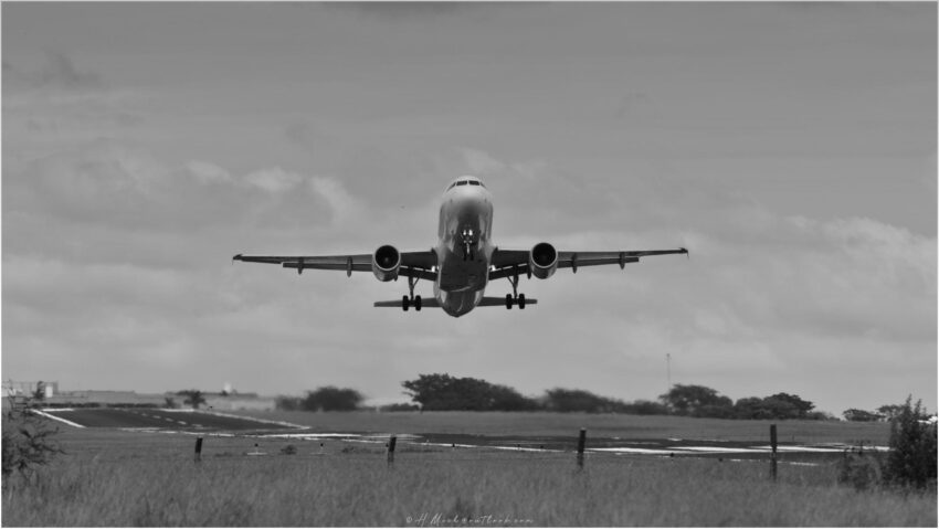 StudioOne Repo – Fotografia PB de um avião decolando.