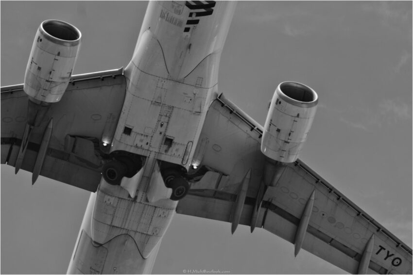 StudioOne Repo – Fotografia PB de um avião no céu.