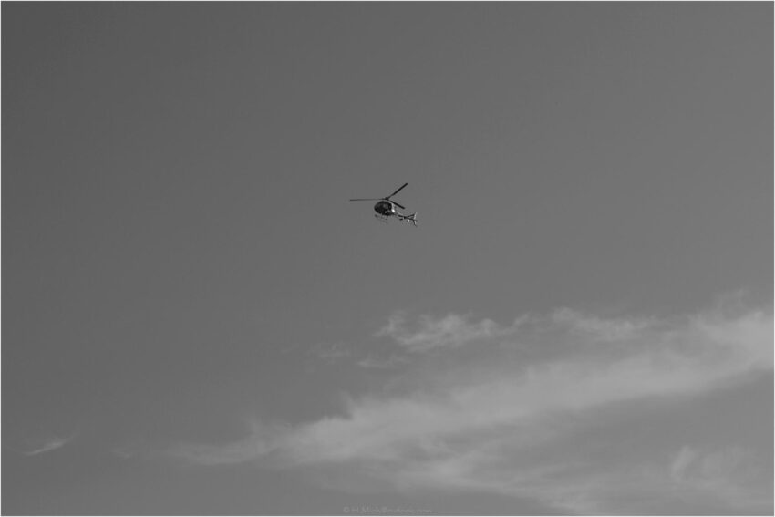 StudioOne Repo – Fotografia PB de um helicóptero voando no céu.