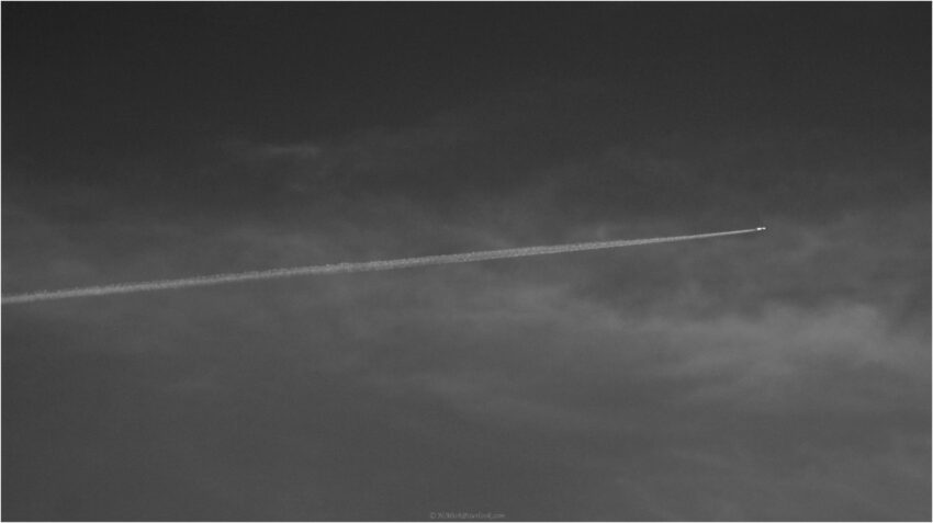 StudioOne Repo – Uma Foto um avião que está voando no céu com um contrail.
