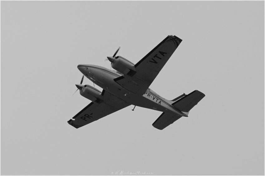 StudioOne Repo – Foto em preto e branco de um avião voando no céu.