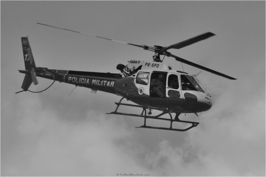 StudioOne Repo – Fotografia PB de um helicóptero voando no céu.