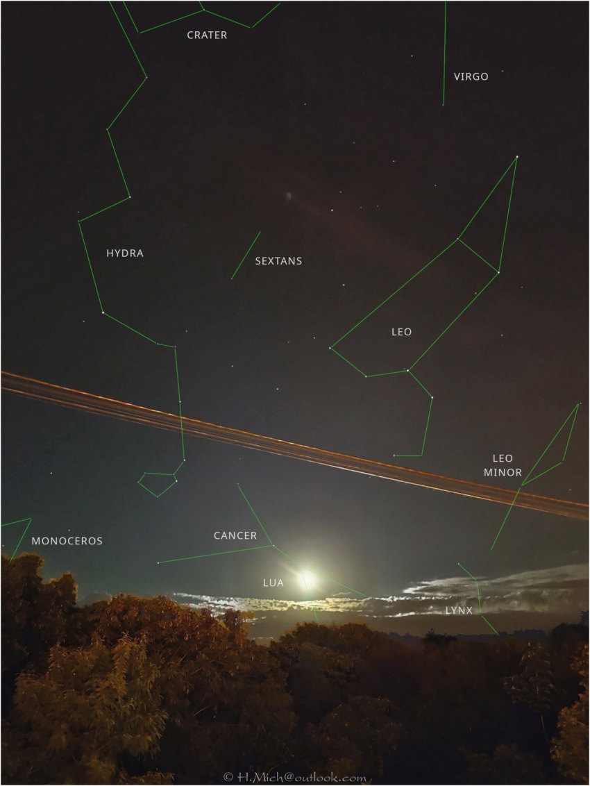 Diarium.Studio-One.Art.Br - Céu noturno sobre uma paisagem escura com várias constelações rotuladas: Hydra, Sextans, Leo, Leo Minor, Virgo, Crater, Monoceros, Cancer e Lynx. Linhas verdes conectam estrelas para delinear cada constelação. A lua brilha perto do horizonte, parcialmente obscurecida por nuvens e árvores. - (c) H.Mich