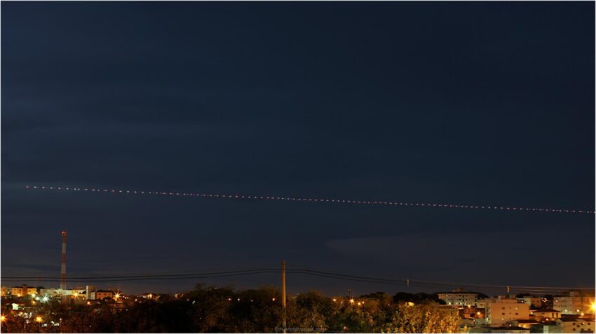 StudioOne Repo – Uma Foto um avião que está voando no céu à noite.