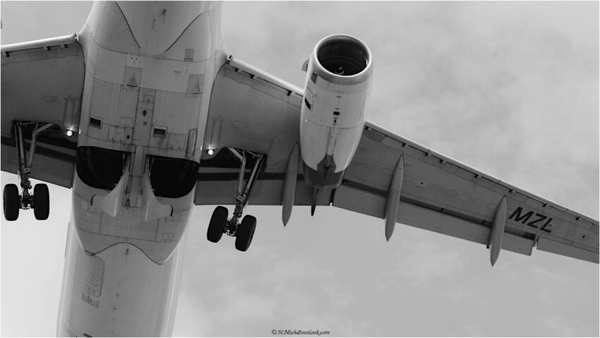 StudioOne Repo – Foto em preto e branco de um grande avião voando no céu.