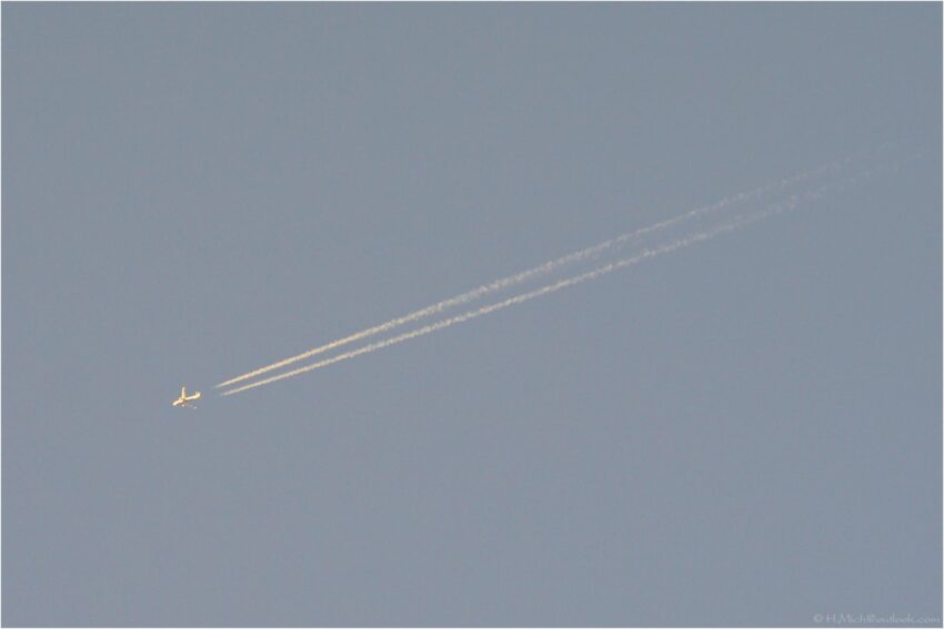 StudioOne Repo – Uma Foto um avião que está voando no céu com os contrails.