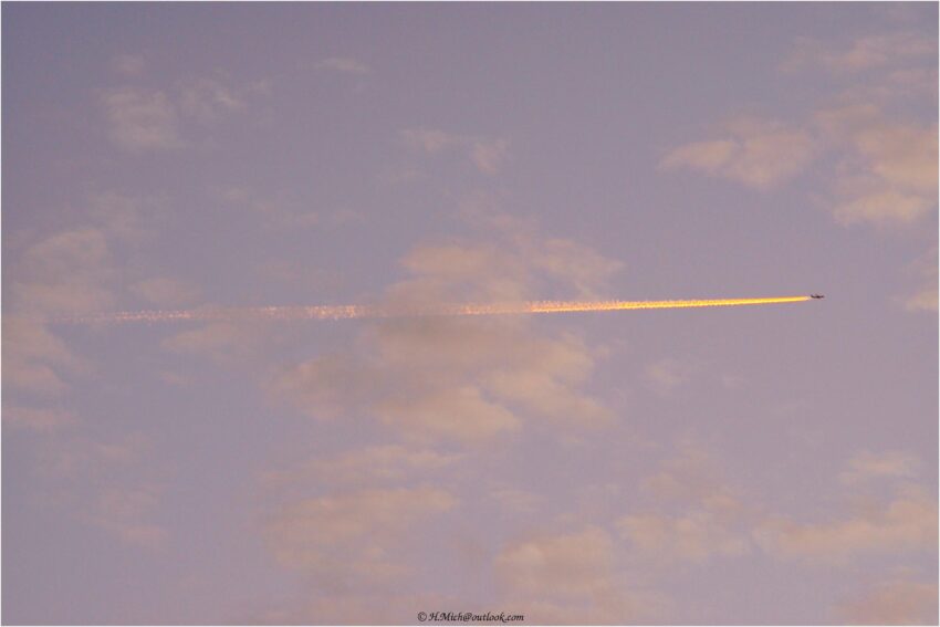StudioOne Repo – Uma Foto um avião que está voando no céu com um contrail.